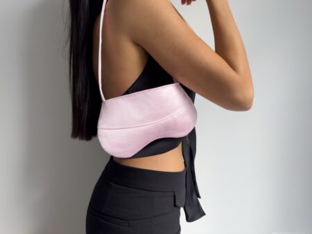 Vista lateral de mini bolso baguette rosa llevado al hombro